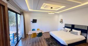 um quarto com uma cama, uma mesa e cadeiras em Maison d'Hotes Oasis Marrakech Route dOuarzazate em Oulad Akkou
