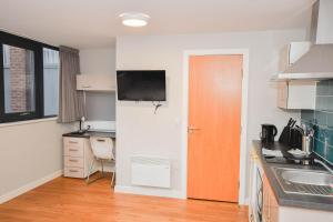eine Küche mit einem Waschbecken, einem Schreibtisch und einer Tür in der Unterkunft Convenient Budget Studio in Central Sheffield in Midland + 34 Fotos