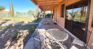 Un patio con una mesa y sillas en una casa. en Maison d'Hotes Oasis Marrakech Route dOuarzazate, en Oulad Akkou