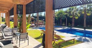 Un patio con sillas y una piscina. en Maison d'Hotes Oasis Marrakech Route dOuarzazate, en Oulad Akkou