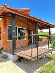 ein Holzhaus, vor dem ein Hund lag in der Unterkunft Chalés das Cachoeiras - Amor Perfeito in Resende