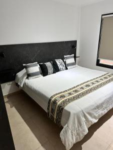 Siempre Verde في تانديل: سرير كبير ومخدات عليه في الغرفة