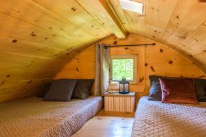 two beds in a room in a log cabin at POD'Stress Nature et Tranquilité in Saint-Alexis-des-Monts