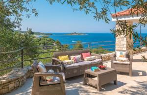 un patio con sedie, divano e tavolo di The Stone House a Oziás