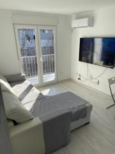 a bedroom with a large bed and two windows at Piso trabajo Rocafort 2 in Madrid