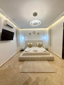 a bedroom with a large bed and a flat screen tv at Villa Dar Soka in Marrakesh +38 photos