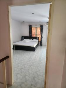 a bedroom with a bed and a tiled floor at Doze House Patong Phuket in Patong Beach