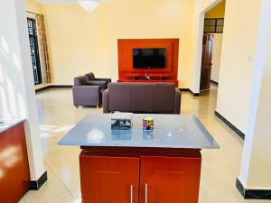 een woonkamer met een bank en een tv bij CnRAirBnB in Iringa