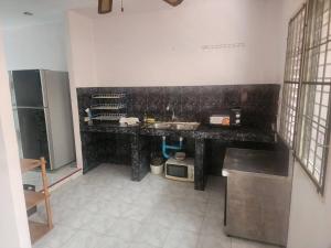 a kitchen with a black counter top in a room at Doze House Patong Phuket in Patong Beach +4 photos