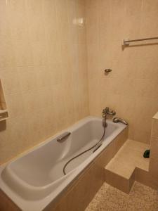 a white bath tub with a faucet in a bathroom at Doze House Patong Phuket in Patong Beach