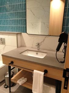 ein Badezimmer mit Waschbecken und Spiegel in der Unterkunft Orchid Park in Bangalore