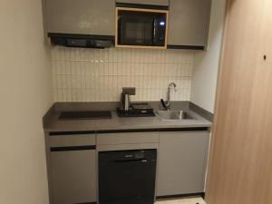 eine kleine Küche mit Spüle und Mikrowelle in der Unterkunft Orchid Park in Bangalore