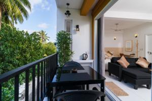a balcony with a black table and a couch at La Sky Stay in Ukulhas