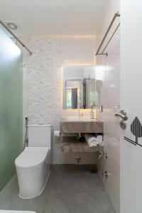 a bathroom with a toilet and a sink and a mirror at La Sky Stay in Ukulhas +26 photos
