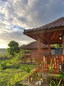 eine Holzhütte mit einem Tisch und Stühlen davor in der Unterkunft The Mawun Lombok in Selong Belanak