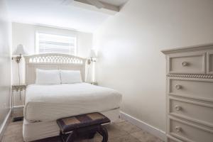 a white bedroom with a bed and a dresser at Sea Breeze -Great Location! in Key West