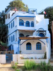 Un edificio azul y blanco con un balcón. en Nubian Lotus, en Asuán