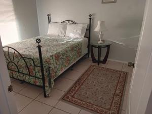 a bedroom with a bed and a table with a lamp at GpL 3115 A Family Get Away in Fort Myers