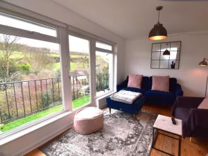 a living room with a blue couch and two large windows at 2 Bed in Wareham oc-79228 in West Lulworth