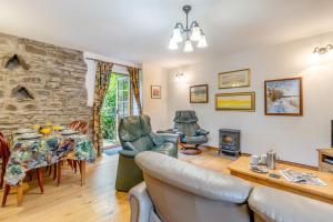 ein Wohnzimmer mit einem Tisch, Stühlen und einer Steinmauer in der Unterkunft 2 Bed in Knighton oc-t29330 in Felindre