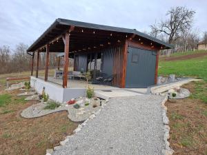 eine kleine Hütte mit einem Dach auf einem Feld in der Unterkunft Cuibul de pe Deal Coșdeni Bihor 