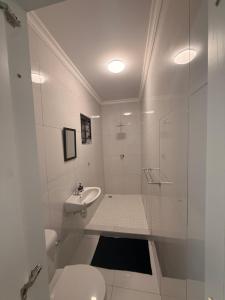 a white bathroom with a toilet and a sink at 268 Self-catering Apartments in Swakopmund +57 photos