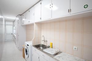 una cocina con fregadero y lavadora en Ferienhaus Treibholz, en Funchal