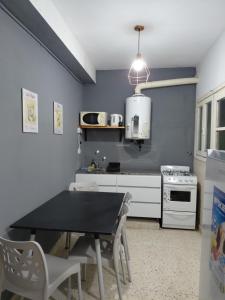 a kitchen with a black table and a kitchen with a stove at Nami in Necochea