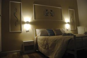 a bedroom with a bed with two lights on the wall at Coro & Bentu in Alghero