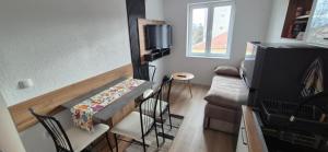 una pequeña sala de estar con mesa y TV en TESLA 132 Apartment 9, en Bitola