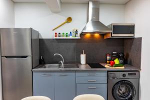 a kitchen with a sink and a washing machine at LaurissilvaLodge in Senhora do Rosário