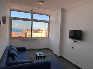 a living room with a couch and a large window at Ewa in Hurghada