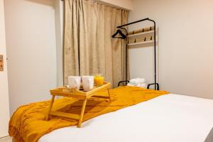 a bed with a tray with three candles on it at LaurissilvaLodge in Senhora do Rosário