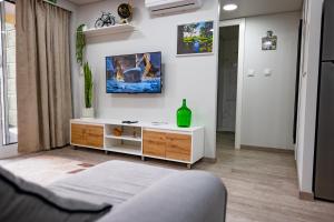 a living room with a bed and a tv on the wall at LaurissilvaLodge in Senhora do Rosário