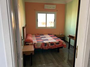 a small bedroom with a bed and a window at Ewa in Hurghada