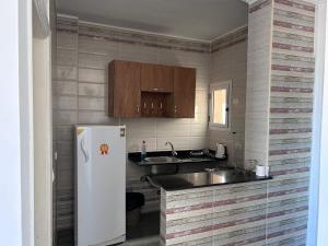 a kitchen with a sink and a white refrigerator at Ewa in Hurghada