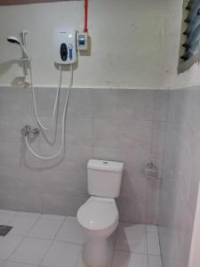 a bathroom with a white toilet and a shower at Walkerz Inn in Panglao Island