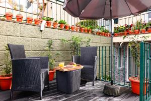 a patio with chairs and a table and an umbrella at LaurissilvaLodge in Senhora do Rosário