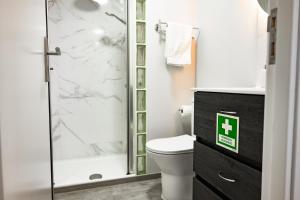 a bathroom with a toilet and a glass shower at LaurissilvaLodge in Senhora do Rosário +9 photos