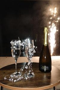 eine Flasche Wein und zwei Gläser auf einem Tisch in der Unterkunft Domki w Dolinie OSTOJA I, Święta i Sylwester w Nowoczesnych Domkach z Kominkiem nad Jeziorem in Mrągowo