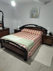 a bed in a room with two nightstands and a bed with avertisement at Casa Engracia in Arcos