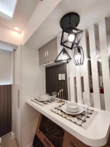 een keuken met een tafel met borden en wijnglazen bij Z Crib - Azure North in San Fernando +14 foto's