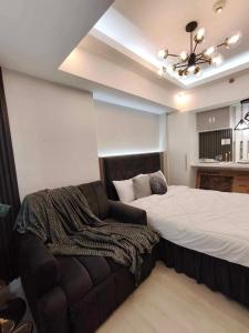 een slaapkamer met een bed en een bank bij Z Crib - Azure North in San Fernando