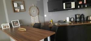 a kitchen with a wooden table and a counter at Relax Wellness Apartman in Pusztavacs +6 photos