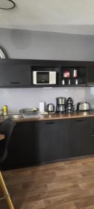 a kitchen with a stove and a microwave at Relax Wellness Apartman in Pusztavacs