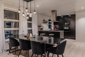 ロングイェールビーンにあるCozy Apartment Longyearのキッチン、ダイニングルーム(黒いテーブル、椅子付)