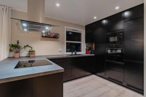 ロングイェールビーンにあるCozy Apartment Longyearのキッチン(黒いキャビネット、カウンタートップ付)