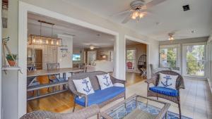a living room with chairs and a dining room at 11 43rd Avenue by AvantStay Pool Close to Beach in Isle of Palms