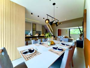 a dining room with a white table and chairs at Casa Completa com Piscina Churrasqueira Wi-Fi a 300m da Praia Acomoda 10 Pessoas, 3 Quartos com Ar-Condicionado in Penha