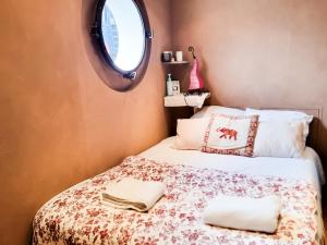 a bedroom with a bed with two towels on it at EXIGEHOME-Large houseboat with spa near Paris in Saint-Cloud